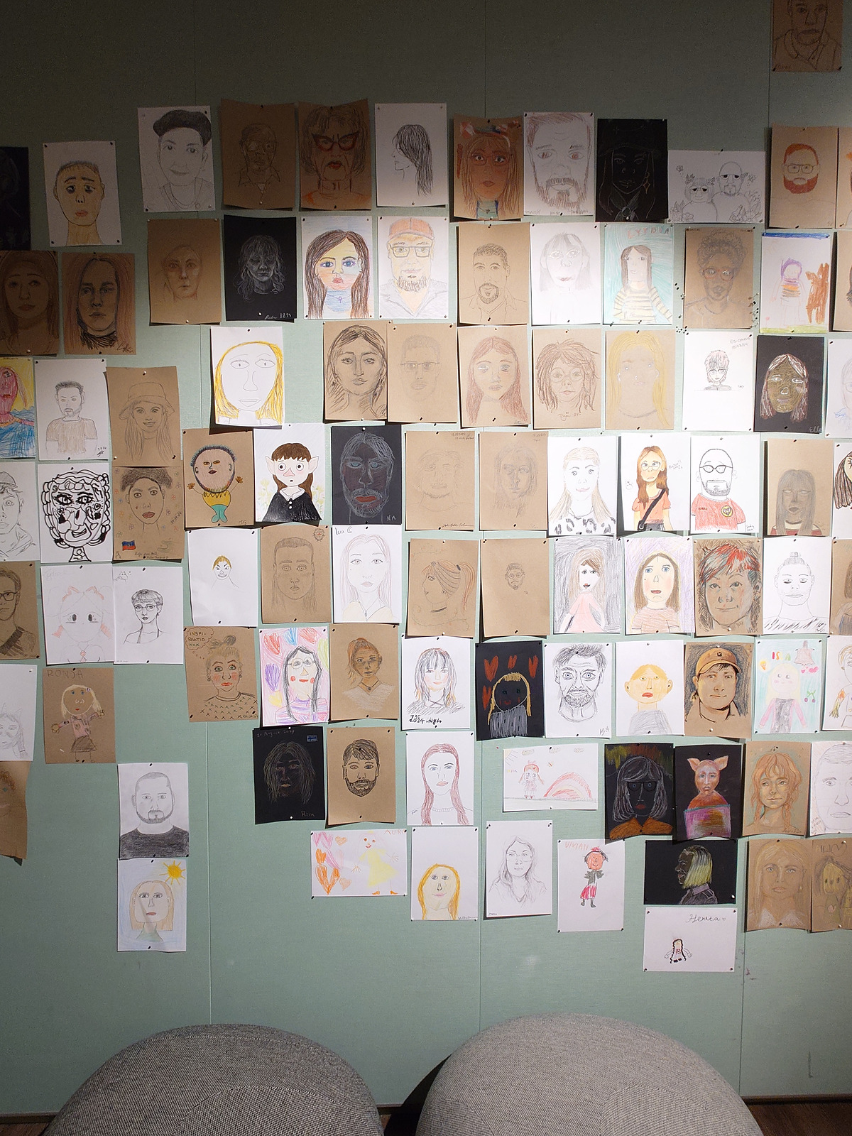世界各国の来館者が描いた似顔絵がびっしり並ぶ展示壁