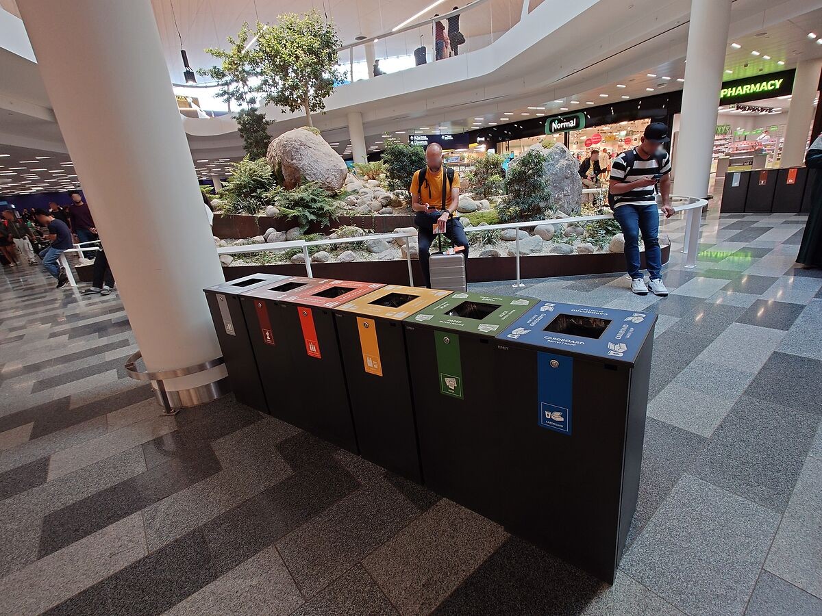 植栽の前に並ぶヘルシンキ空港のカラフルな分別ゴミ箱