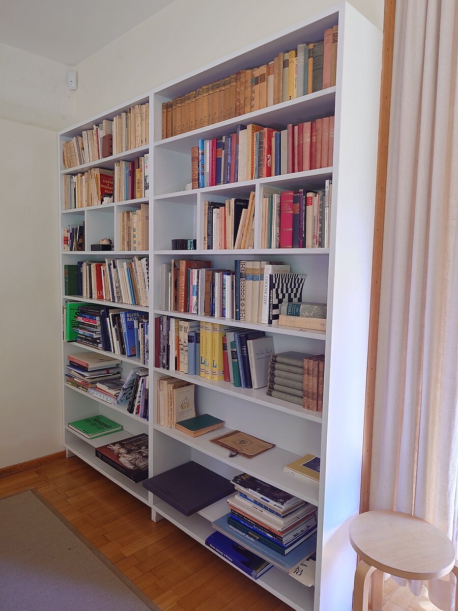 書斎の白い本棚に並ぶ蔵書