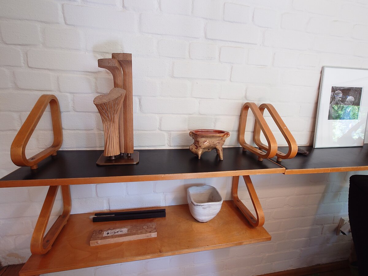棚に飾られた木彫りオブジェと陶器