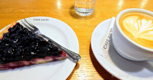 ブルーベリーパイとラテアートのコーヒーが並ぶカフェ・アアルトのテーブル