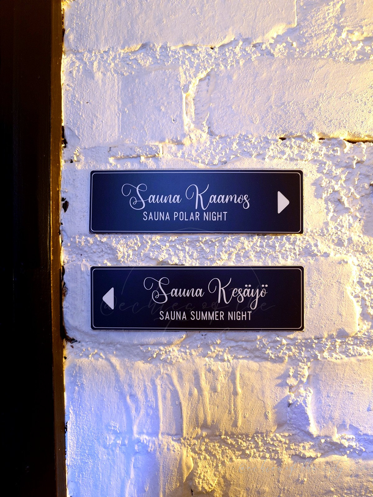 地下のサウナへ案内する「Sauna Kaamos」「Sauna Kesäyö」のサイン